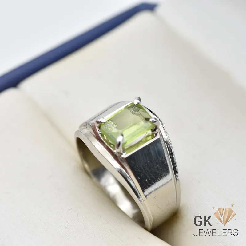 Silver ring featuring a transparent emerald-cut peridot gemstone from Afghanistan, set in a four-prong setting with a polished band