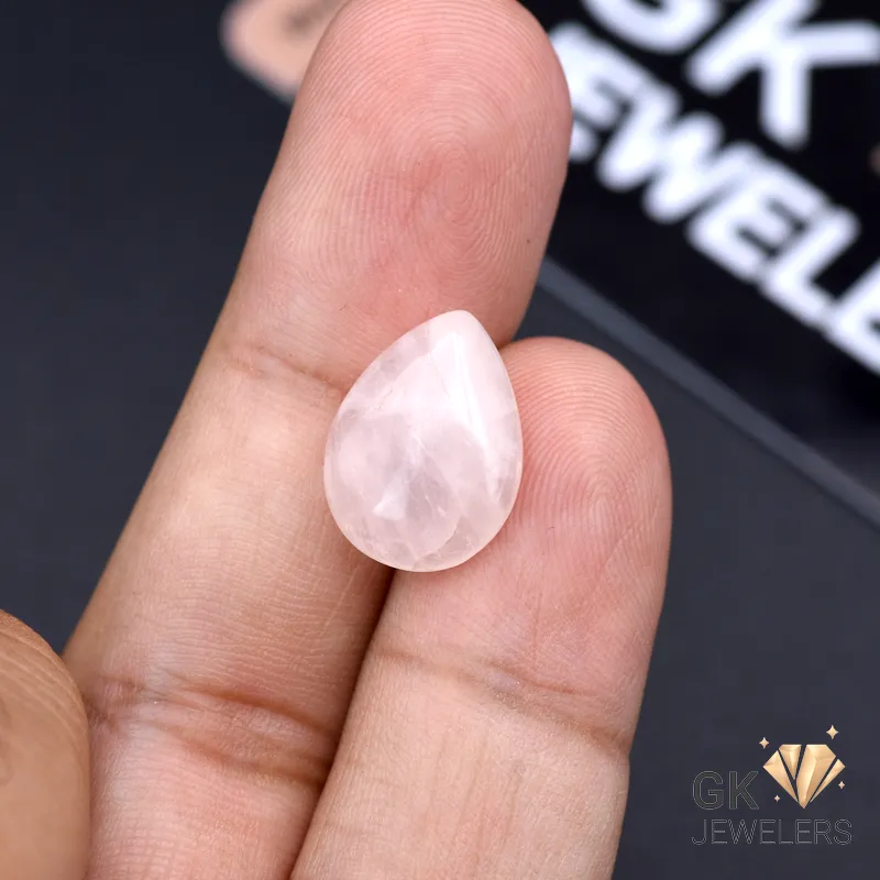 7.40ct African Rose Quartz Gemstone Pear-shaped rose quartz gemstone held between fingers, showcasing translucent pink hue and elegant shape