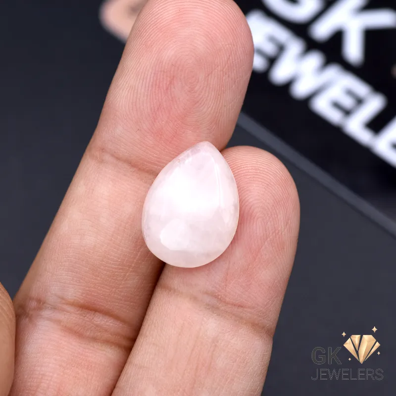 Pear-shaped rose quartz gemstone held between fingers, showcasing translucent pink color and 8.70-carat weight