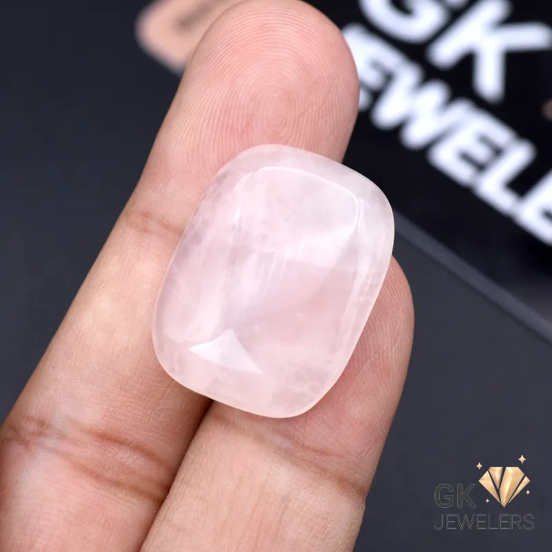 Hand holding a large 29.85ct cushion-cut rose quartz gemstone with pink translucent color, sourced from Africa