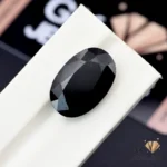 Oval-cut 20.80ct black tourmaline gemstone on white display stand