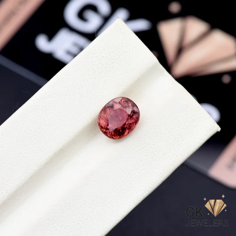 Oval-cut rubylight gemstone on a white display stand, showcasing its pink color and transparent clarity