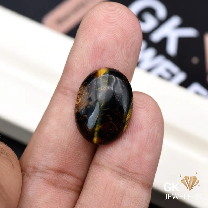 Brazilian Tiger Eye Oval Gemstone 15.70ct Oval Tiger Eye gemstone held between person's thumb and index finger